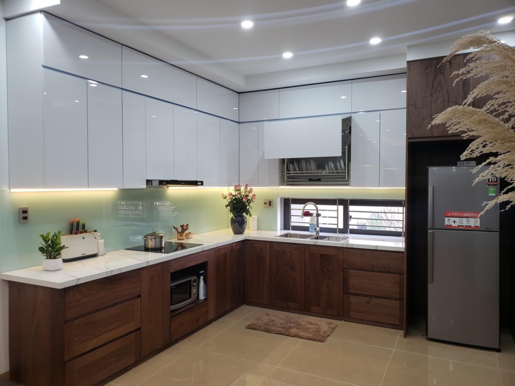 Mẫu tủ bếp 20 | Nội Thất SHC Tủ bếp chữ L có tủ trên trắng bóng, tủ dưới vân gỗ và kính ốp xanh nhạt